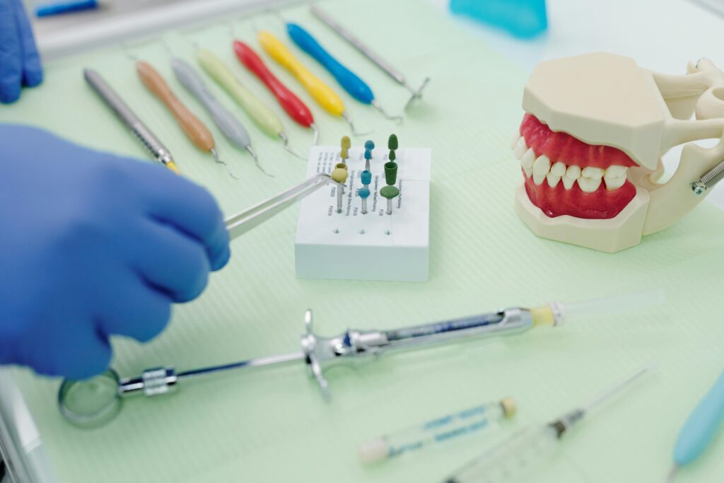 an array of dental tools on a table with a hand choosing the right one