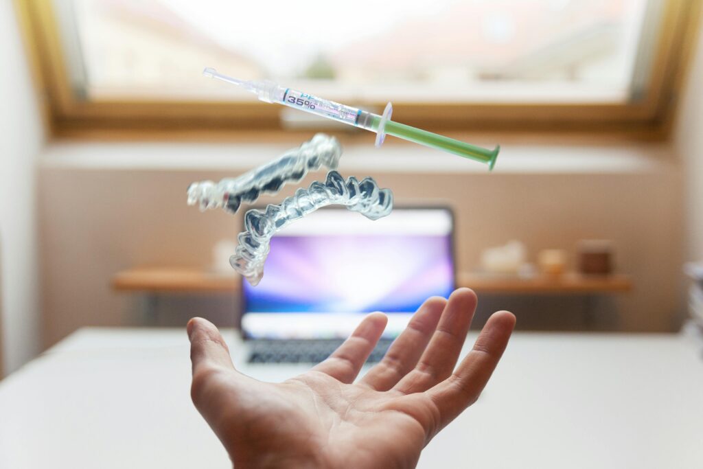 a syringe and false teeth floating above a hand