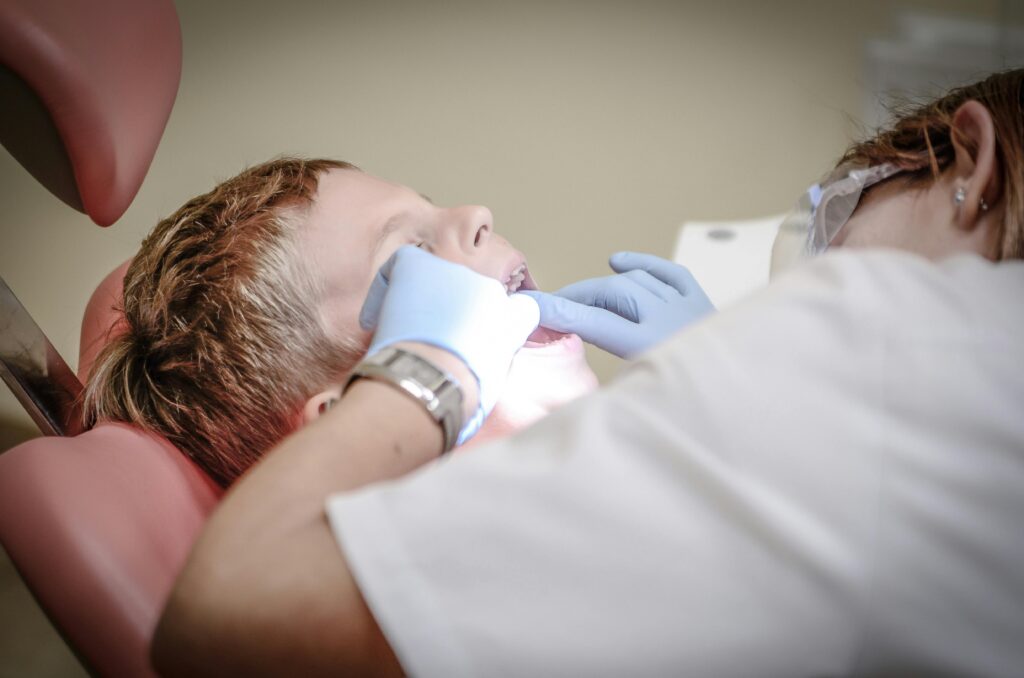 a dentist looking into the mouth of a boy