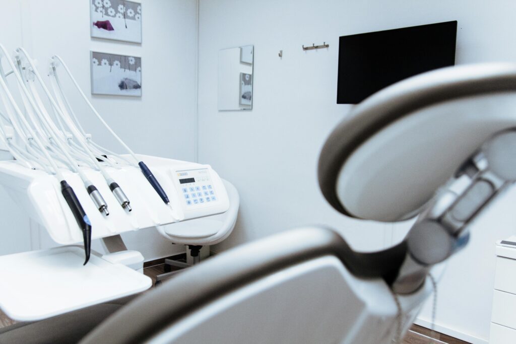 a dental chair leaned back with dental equipment in the back