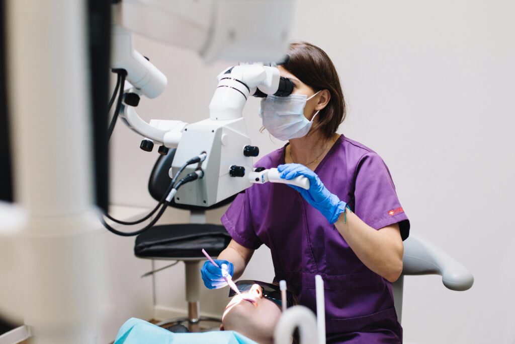 a dentist with an x-ray machine standing over someone in a dental chair