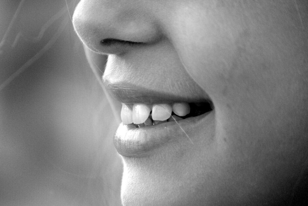 close up of a womans smile in black and white